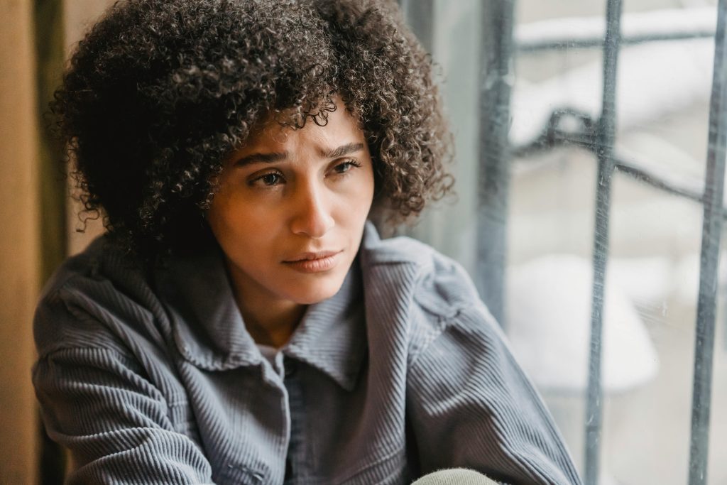 woman sitting alone at a window: how do I know when an adult friendship is ending